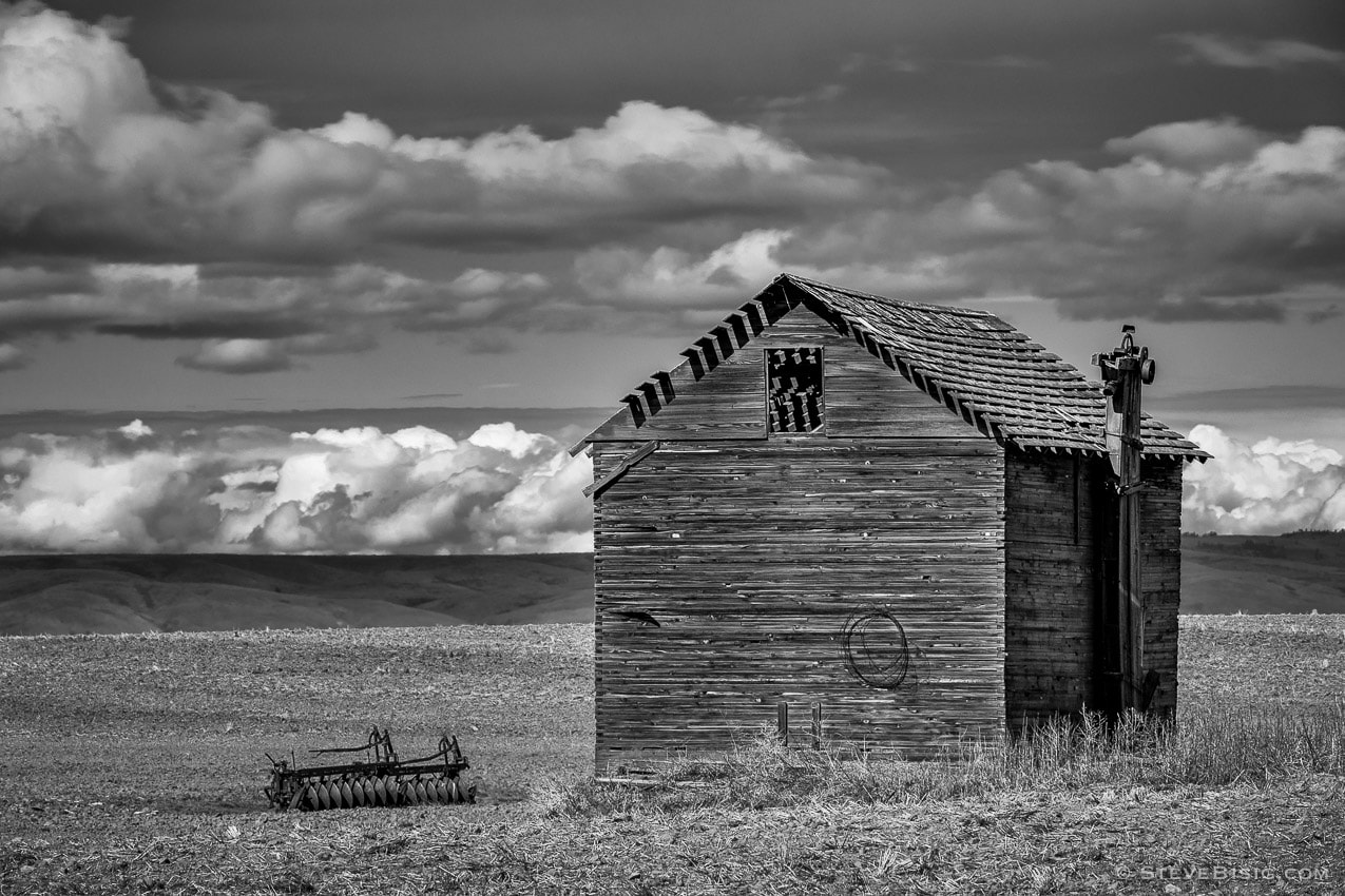 A black and white photograph of old abandoned barn on A Road SW in rural Douglas County, Washington.