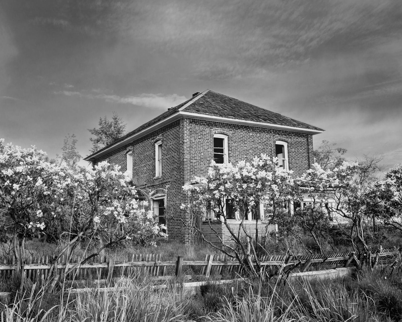 A black and white photograph of old abandoned brick house on D Road NW in rural Douglas County, Washington.