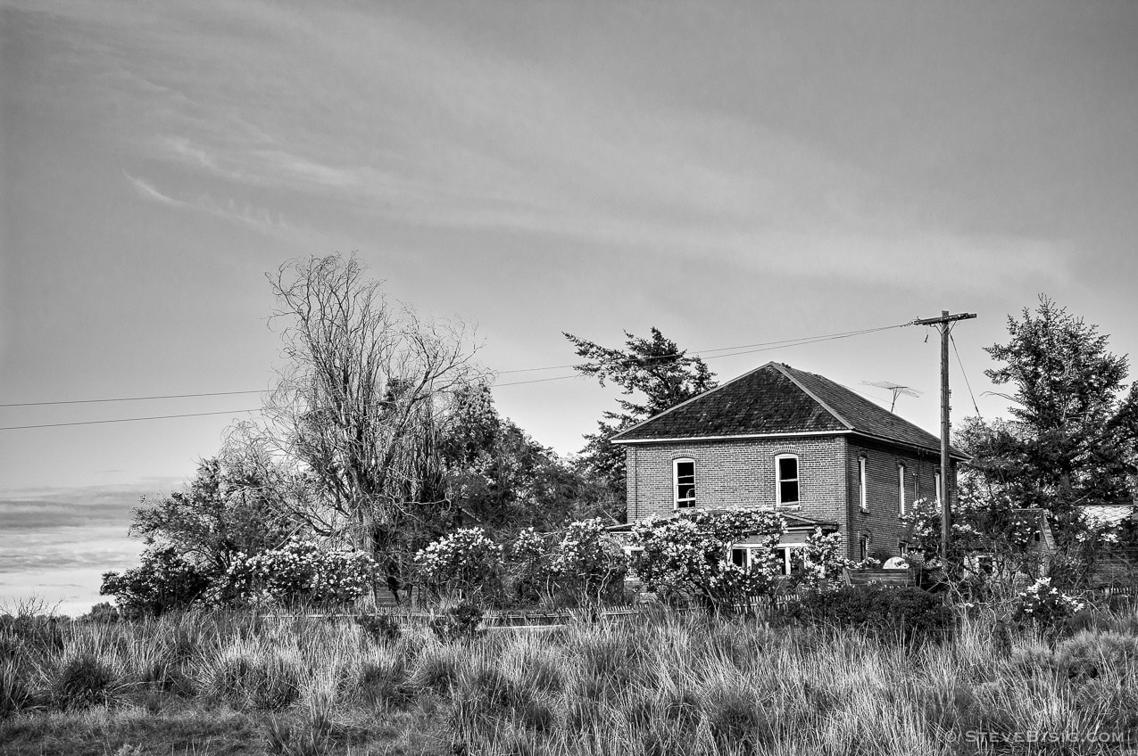 A black and white photograph of an old farmhouse in rural Douglas County, Washington.