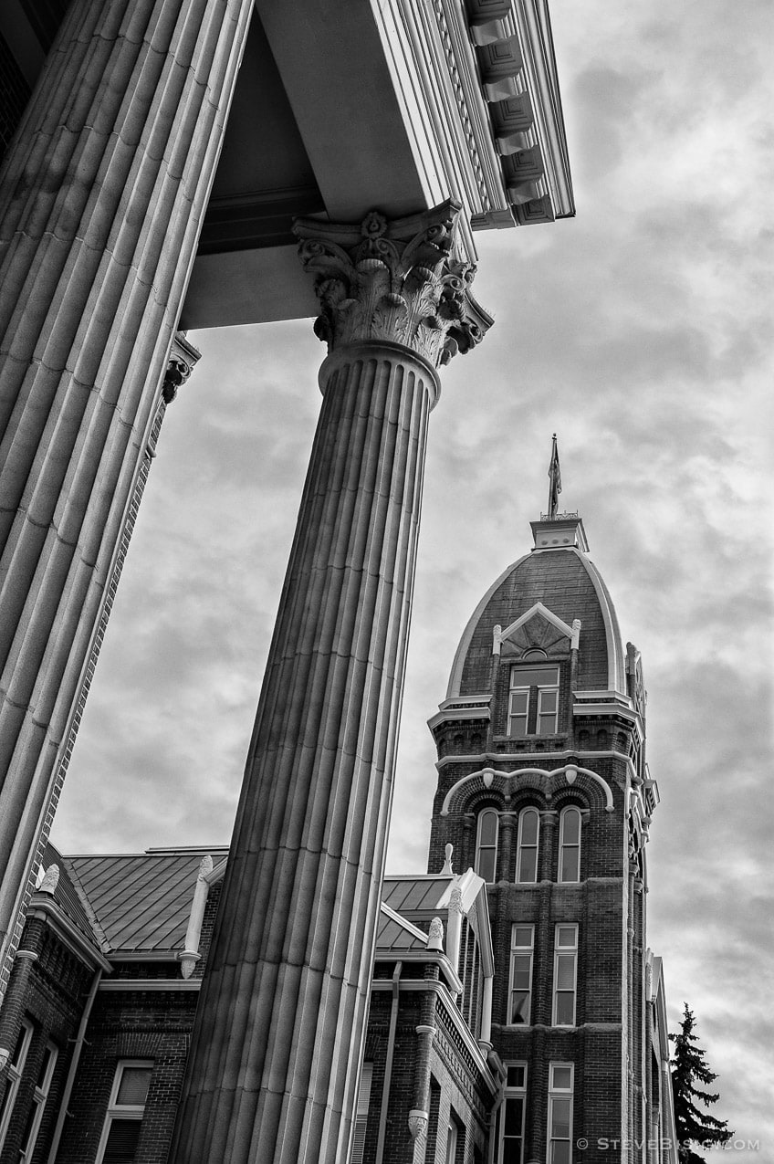 A black and white urban photograph of the tower of Barge Hall and the columns of the Shaw-Smyser Hall, Central Washington University, Ellensburg, Washington.