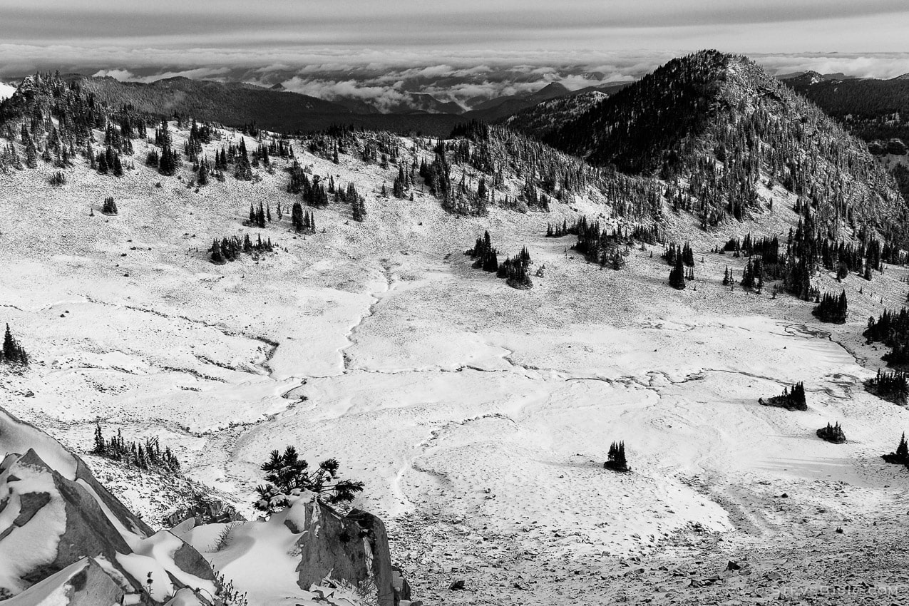 A black and white photograph of the Huckleberry Basin after the first Autumn snow fall as viewed from the Sourdough Ridge Trail at the Sunrise area of Mount Rainier National Park, Washington.