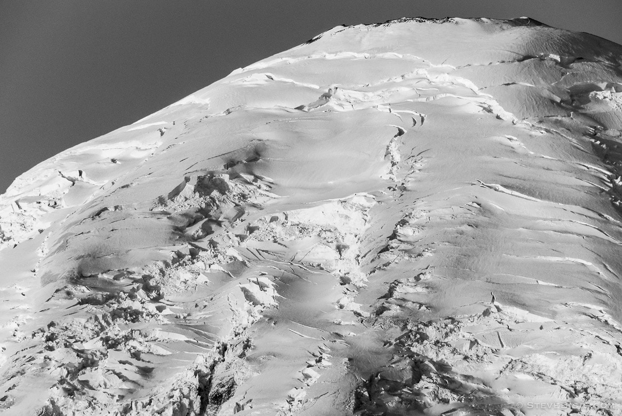 A black and white photograph of the early morning autumn sun shining on a closeup view of the summit of Mt Rainier. Viewed from the Sunrise area at Mount Rainier National Park, Washington.