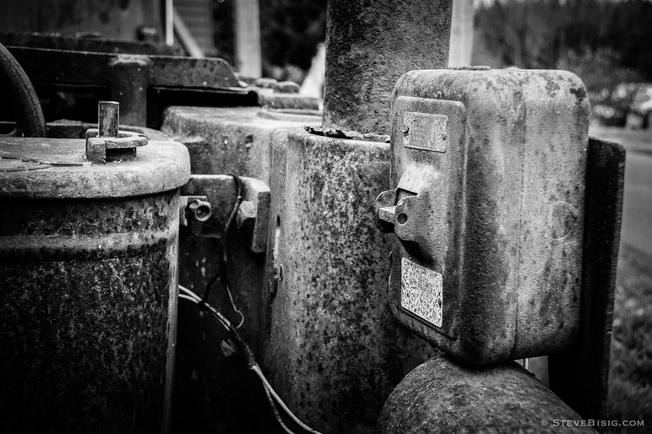A black and white photograph of old rusty coal mining equipment in Black Diamond, Washington.