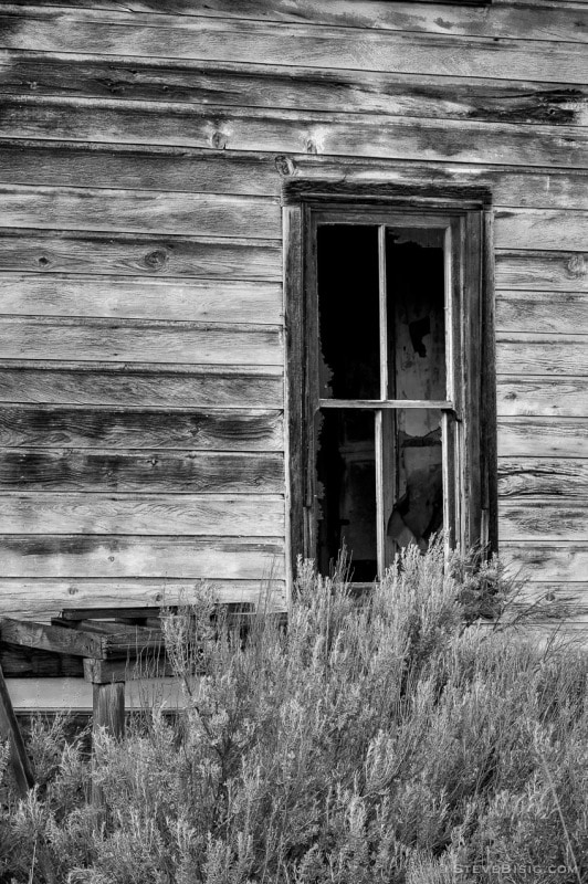 A black and white photograph of a window from an old abandoned house in rural Alstown, Washington.
