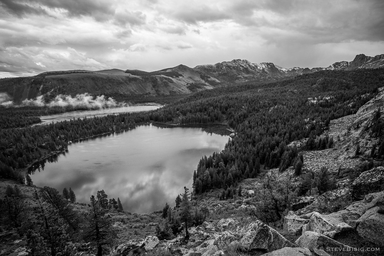 A black and white fine art landscape photograph looking down upon Lake George from the Crystal Lake trail near Mammoth Lakes, California.