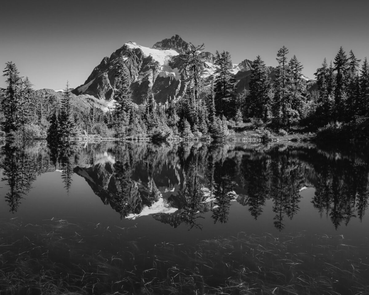 A black and white landscape photograph of Mount Shuksan in the reflection of Picture Lake near Mount Baker Ski Area, Washington.