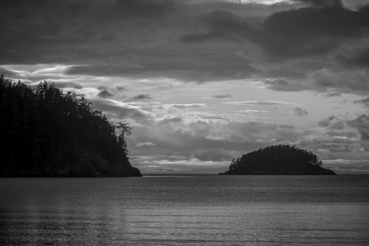 A black and white photograph of Bowman Bay at Deception Pass State Park, Washington on a dark, cloudy Winter afternoon.
