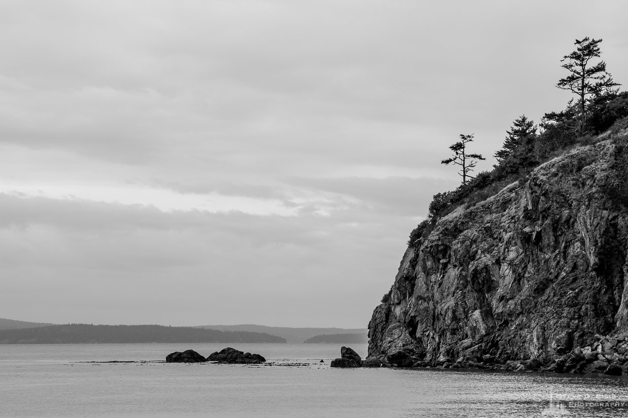 A black and white landscape photograph of the rock cliffs near Rosario Beach at Deception Pass State Park on Fidalgo Island, Washington.