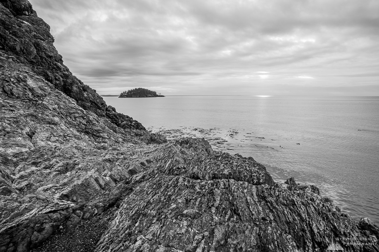 A black and white landscape photograph of the rocky shores of Rosario Head at Deception Pass State Park on Fidalgo Island, Washington.