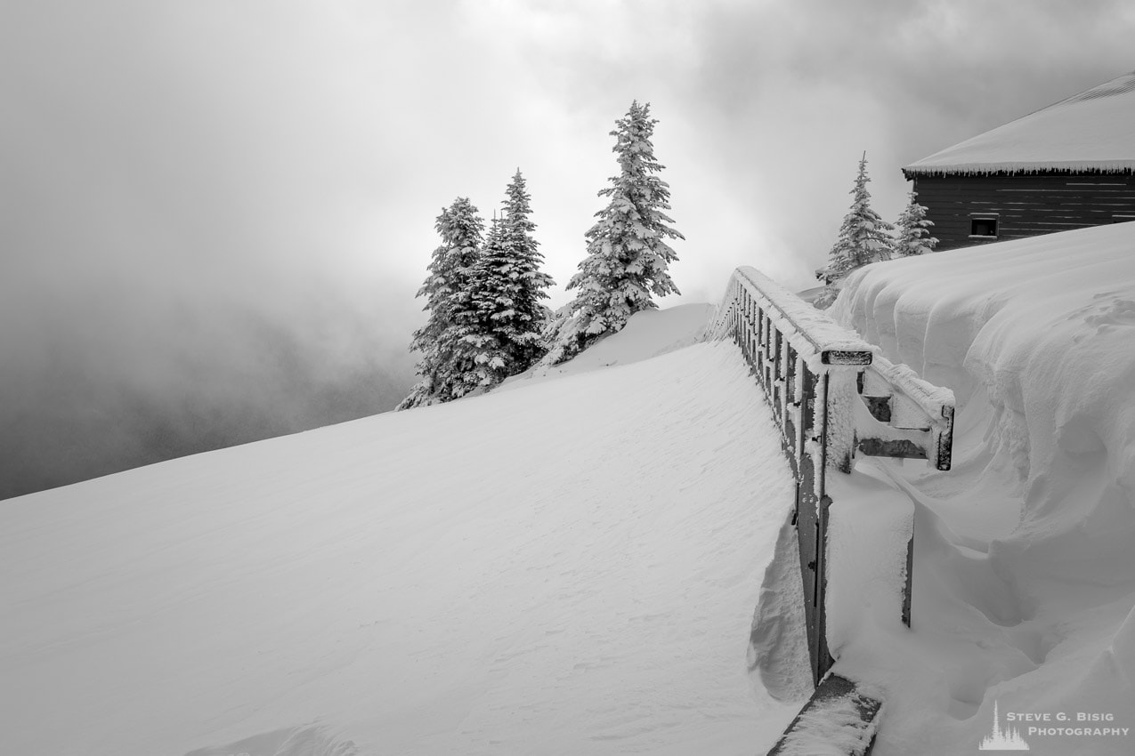 A black and white photograph of the Hurricane Ridge Visitors Center under a blanket of snow during Winter in the Olympic National Park, Washington.