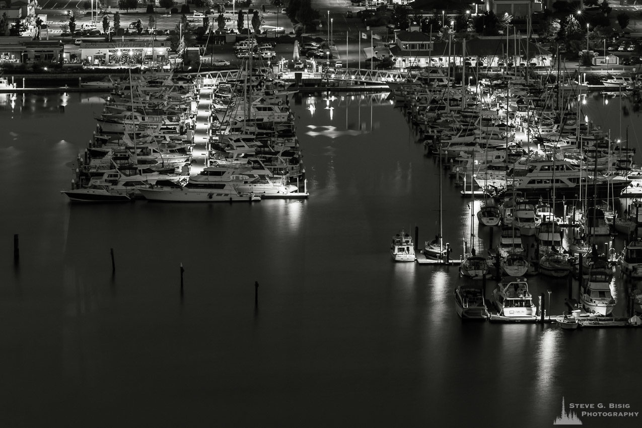 A black and white photograph of the Cap Sante Marina as viewed from Cap Sante Park in Anacortes, Washington just before dawn.