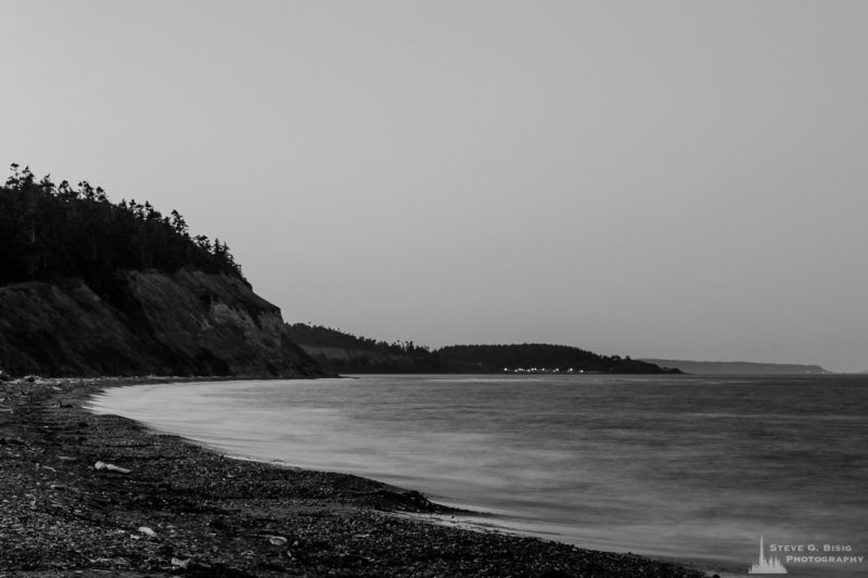 A black and white, long exposure photograph of the shoreline of Ebey's Landing on Whidbey Island near Coupeville, Washington before first light on a clear August morning.