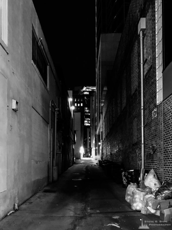 A black and white mobile street photograph of a back alley in Seattle, Washington after dark on a Winter night.