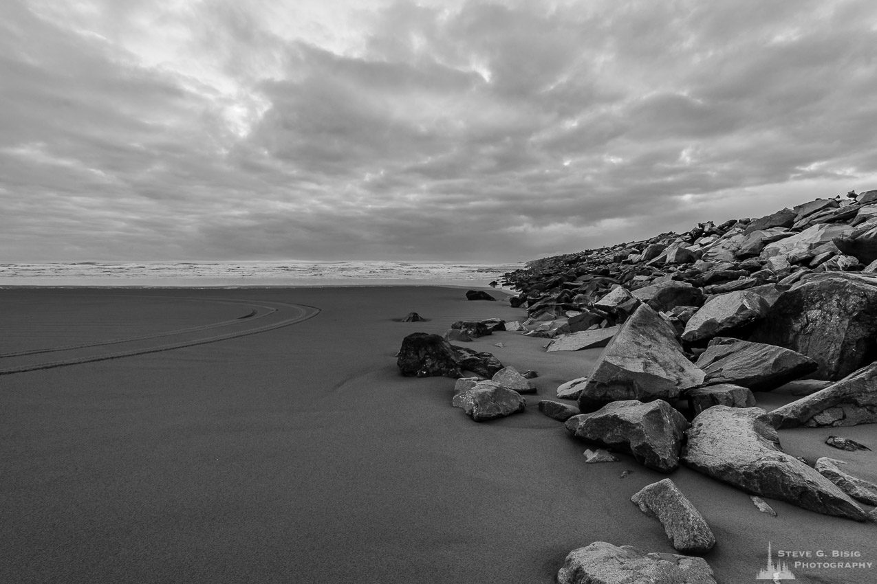 A black and white landscape photograph of the Pacific Ocean and beach along the South Jetty of Grays Harbor at Westhaven State Park near Westport, Washington.