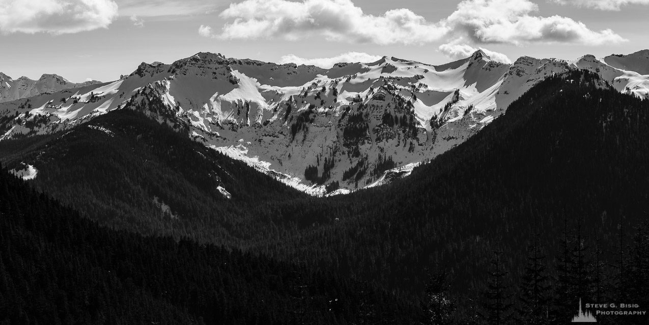 A black and white panoramic photograph of the Clear Fork Cowlitz River valley and the surrounding snow covered Coyote Ridge in the Goat Rocks Wilderness Area as viewed from Gifford Pinchot National Forest Road 1284 in Lewis County, Washington.