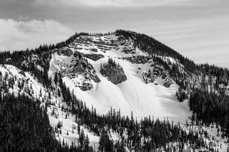 A black and white landscape photograph of a snow-covered Hogback Mountain as viewed from Gifford Pinchot National Forest Road 1284 in Lewis County near White Pass, Washington.