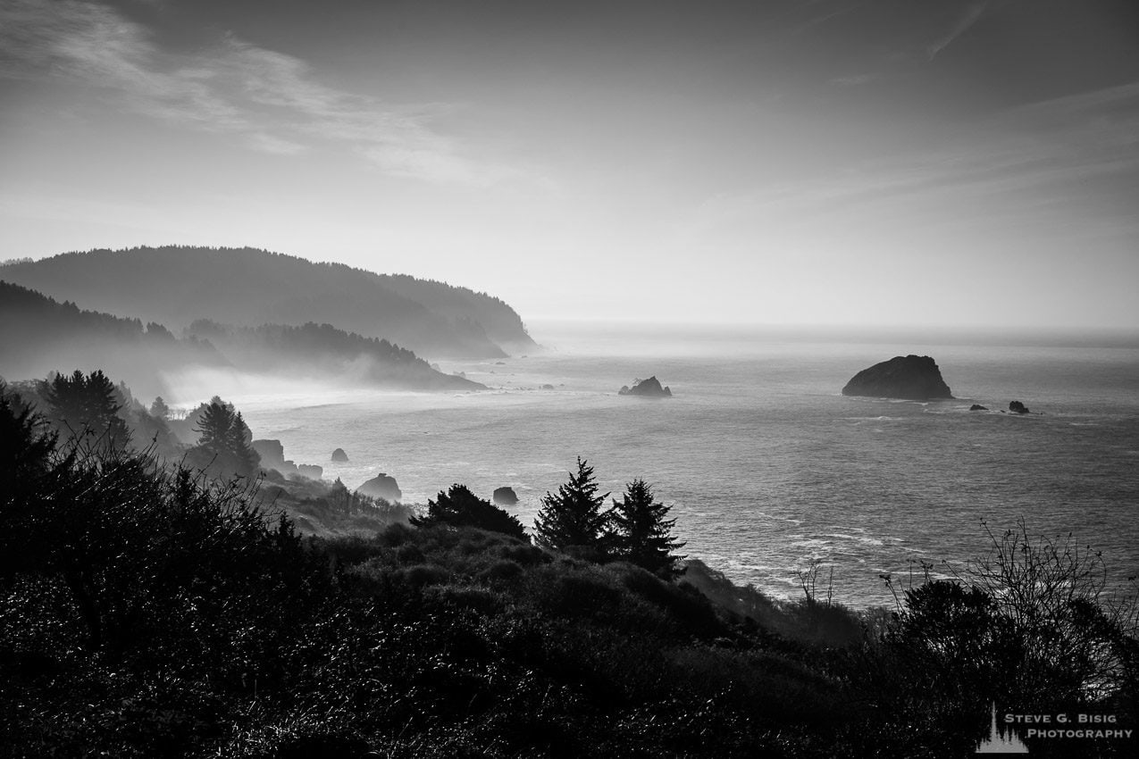 A black and white landscape photograph of the Pacific Ocean and False Klamath Cove at Wilson Creek along Highway 101, California.