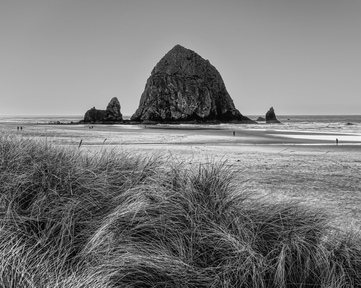 A black and white photograph of Haystack Rock and the Pacific Ocean on an Autumn morning at Cannon Beach, Oregon.