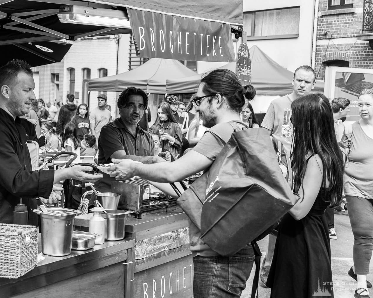Photo 14/32 of a series of black and white photographs from the 2018 Grande Braderie D'Ixelles sidewalk sale and street festival in Brussels, Belgium.