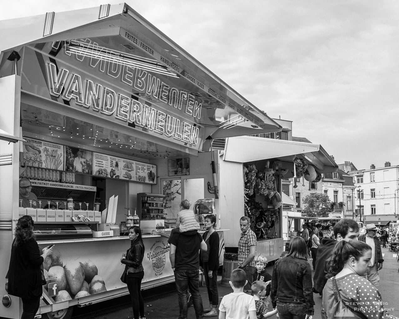 Photo 7/32 of a series of black and white photographs from the 2018 Grande Braderie D'Ixelles sidewalk sale and street festival in Brussels, Belgium.