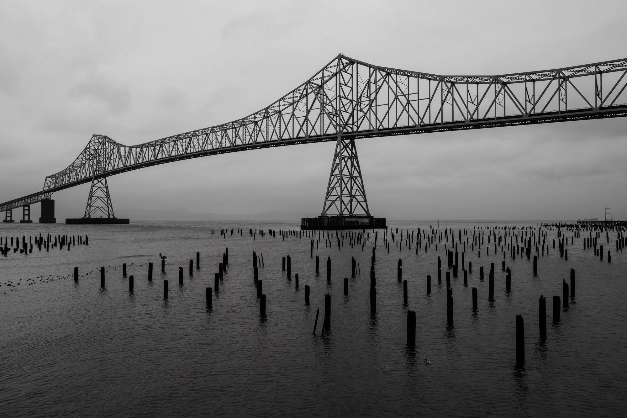 A black and white photograph of the Astoria-Megler Bridge that spans the Columbia River between Oregon and Washington state along US Route 101.