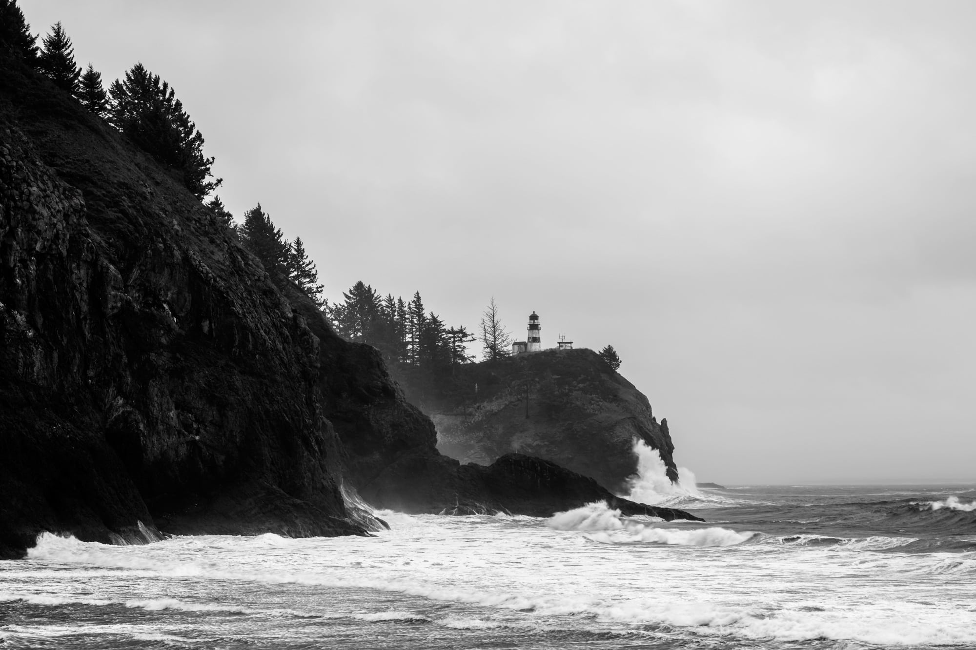 A black and white photograph of Cape Disappointment Lighthouse near Illawco, Washington.