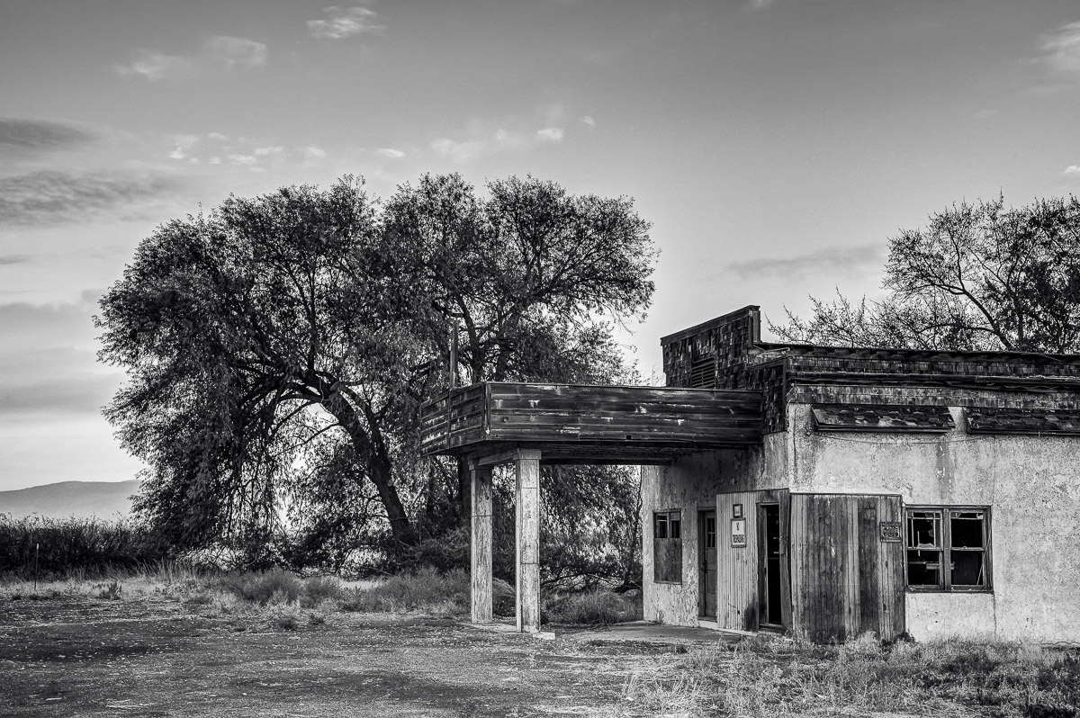 A black and white photograph of an old abandoned gas station in Thrall, Washington.