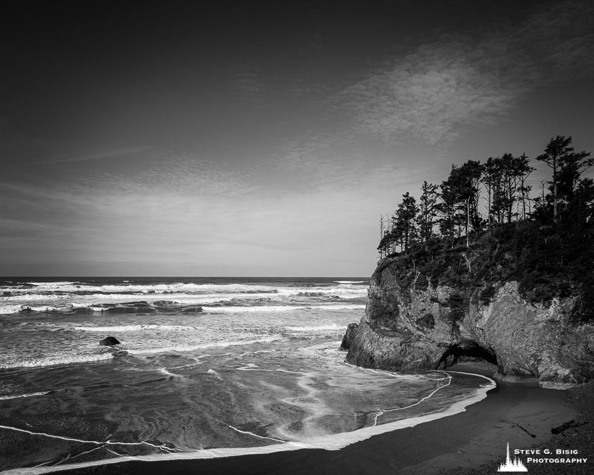 A black and white fine art landscape photograph of the Pacific Ocean and Adair Point as viewed from the Hug Point State Recreation Site, Oregon.
