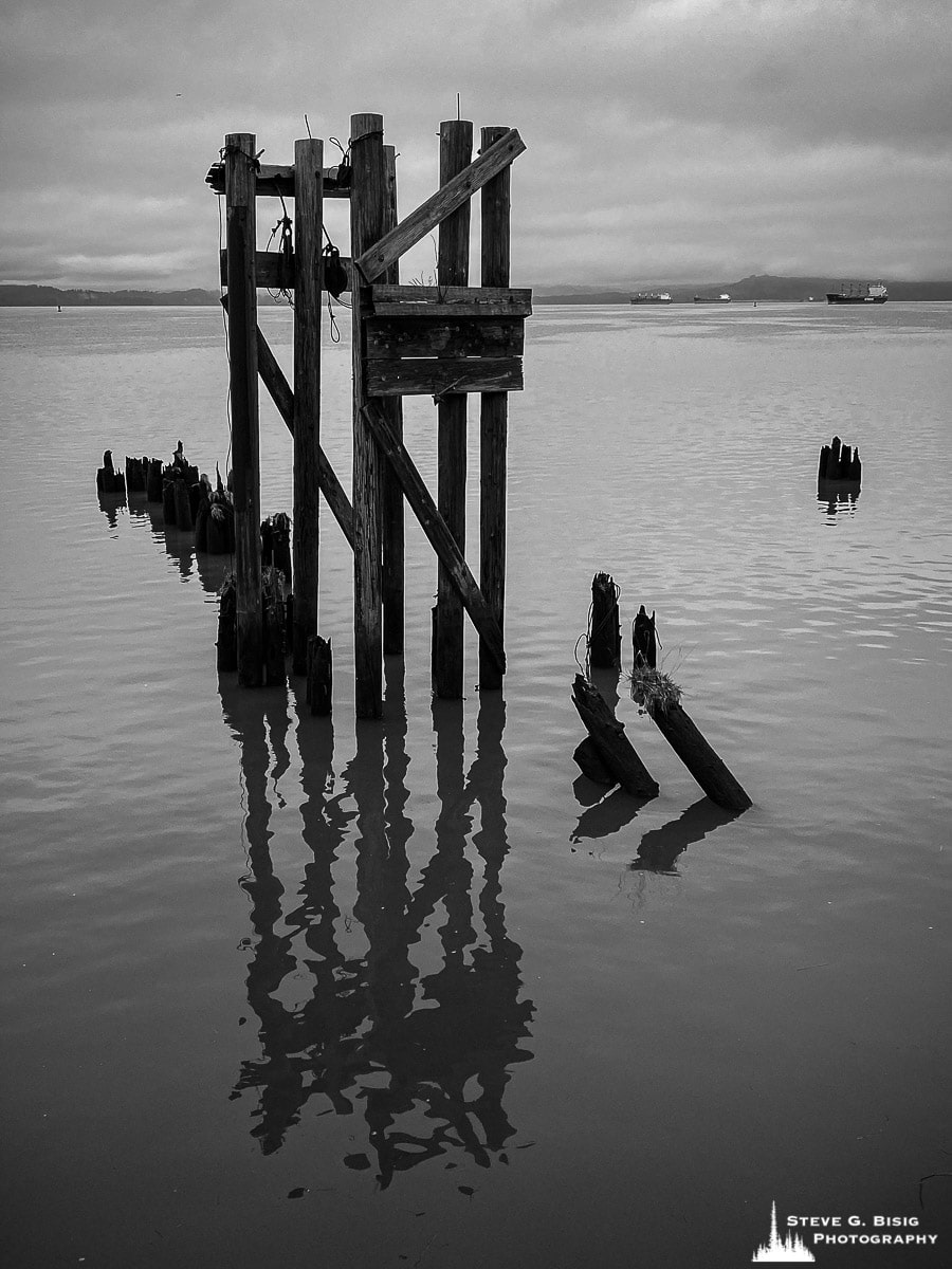 A black and white mobile photograph of old pilings along the historic waterfront at Astoria, Oregon.