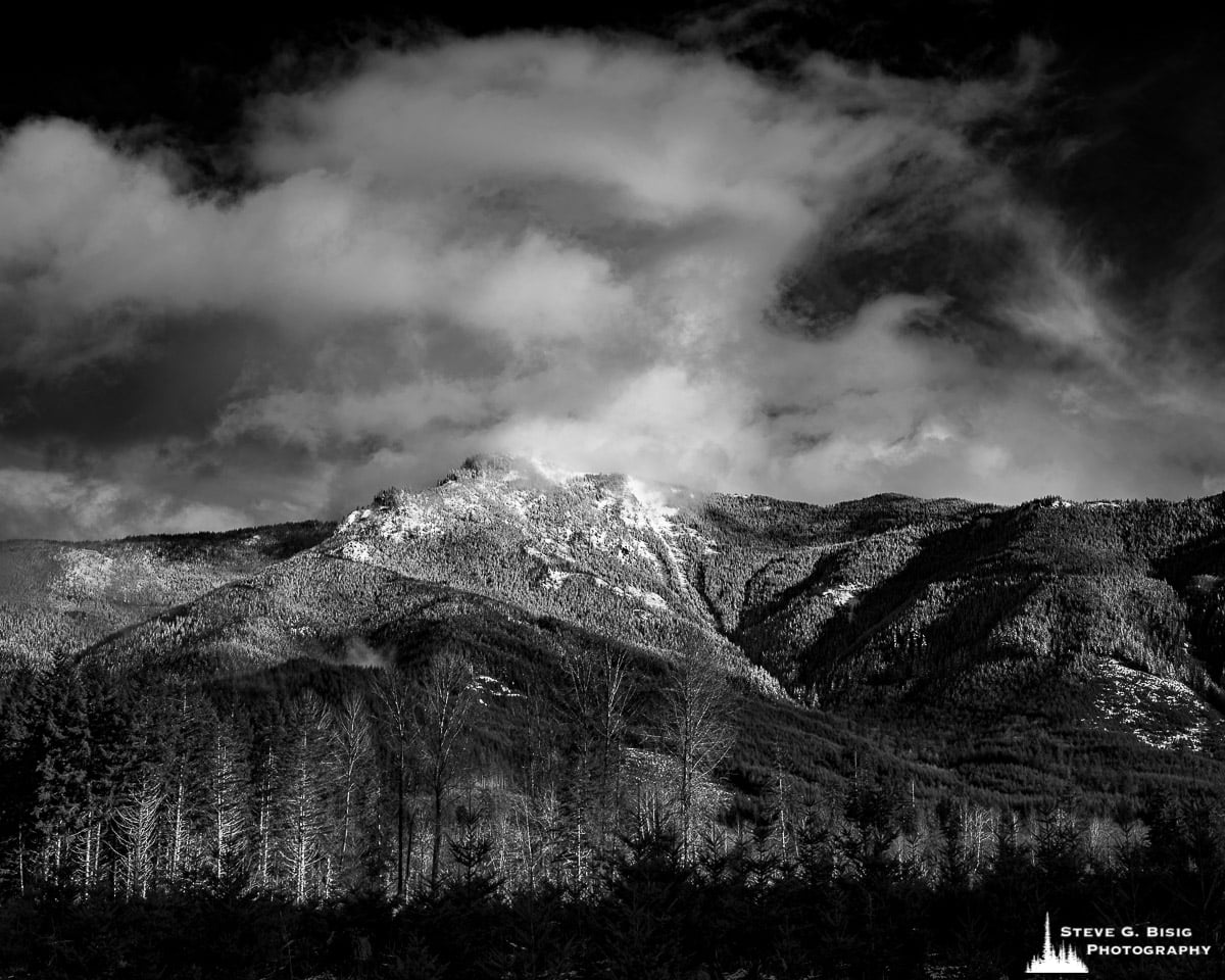 A fine art black and white landscape photograph of a snow-covered Storm King Mountain in rural Lewis County, Washington.