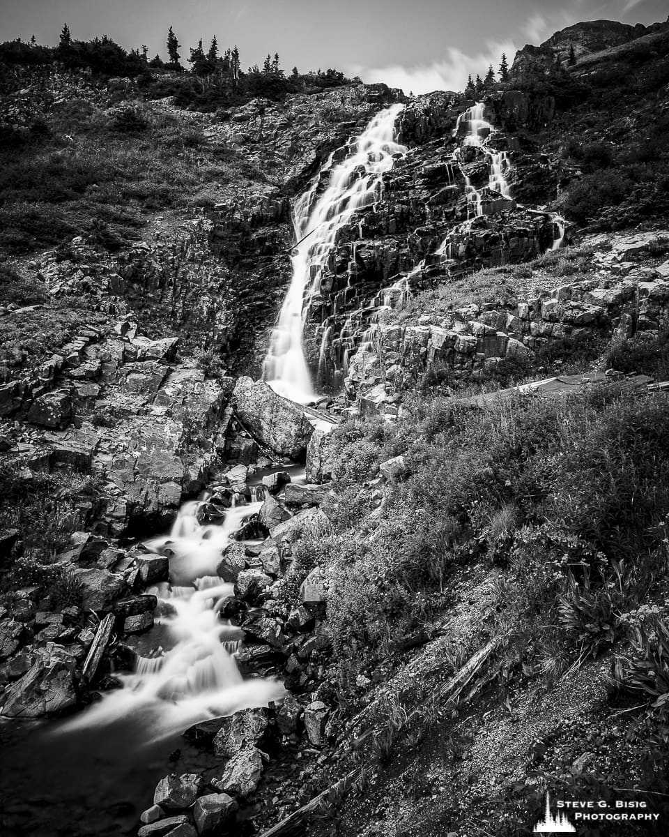 A black and white landscape photograph of a waterfall along Sneffel Creek (elevation 11,143 feet) as viewed from the Yankee Boy Basin Road, Ouray County, Colorado.