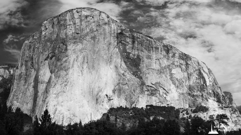 A black and white panoramic landscape photograph of El Capitan in Yosemite National Park, California.