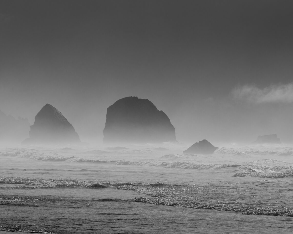 A black and white landscape photograph of the sea stacks off the coastline near Silver Point near Cannon Beach, Oregon.