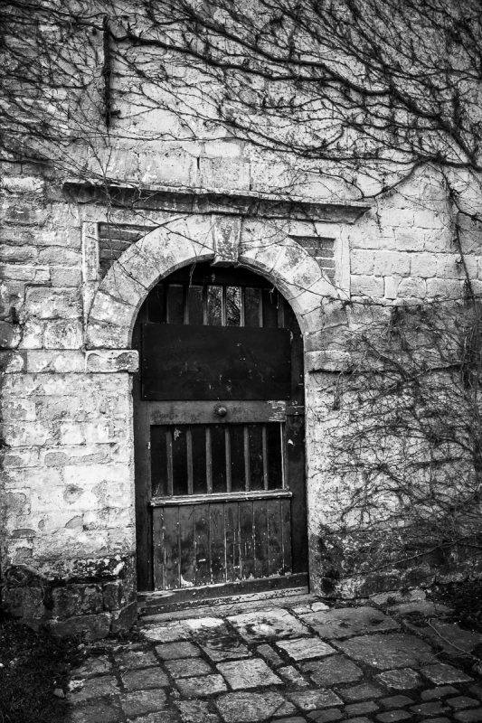 A black and white photograph of the doorway into the Miller's House at the Rouge Cloître in Auderghem, Belgium.