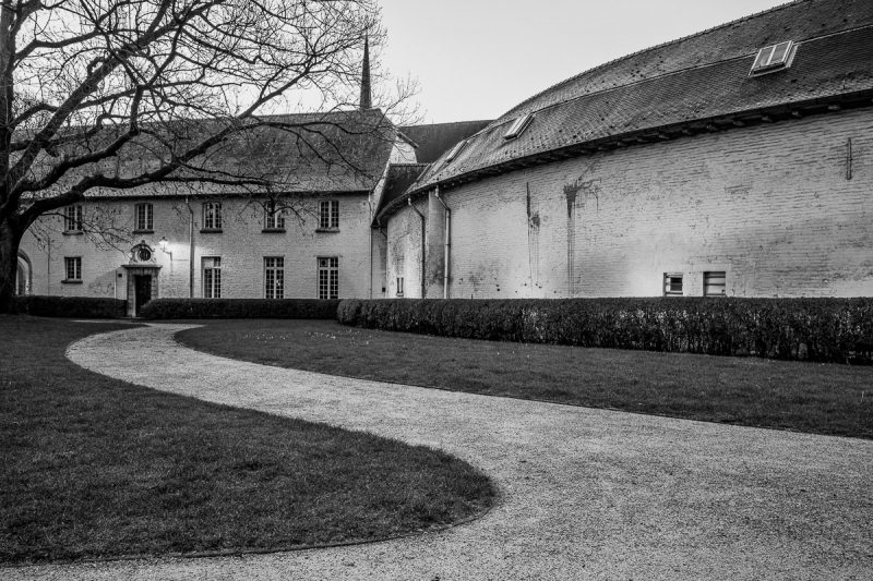 A black and white photograph of the outside grounds of the Abbaye de La Cambre in Brussels, Belgium prior to the sunrise.