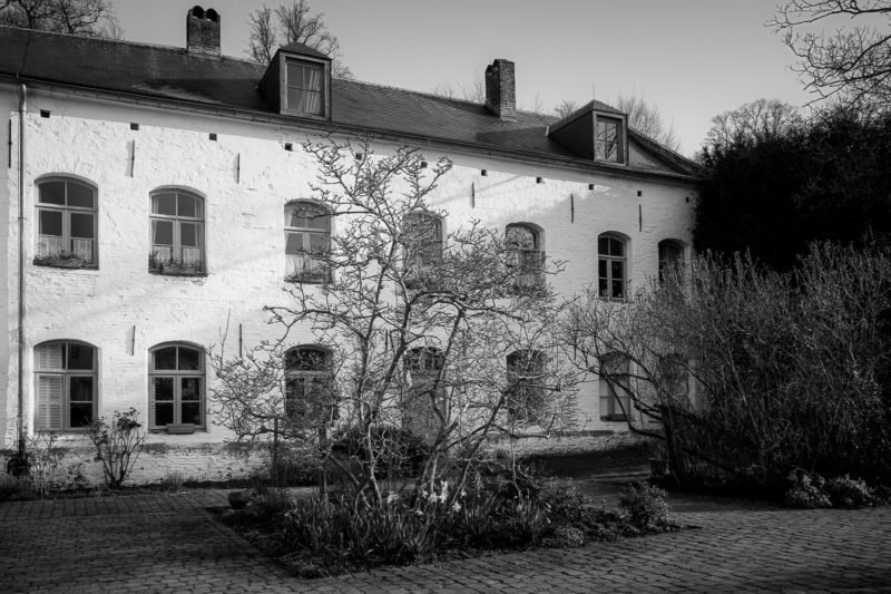 A black and white photograph of Le Porterie (The Gatehouse) at Rouge Cloître, Auderghem, Belgium.