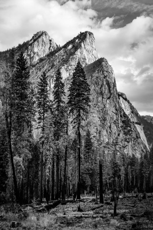 A black and white landscape photograph of the Three Brothers in Yosemite National Park, California on an Autumn morning.