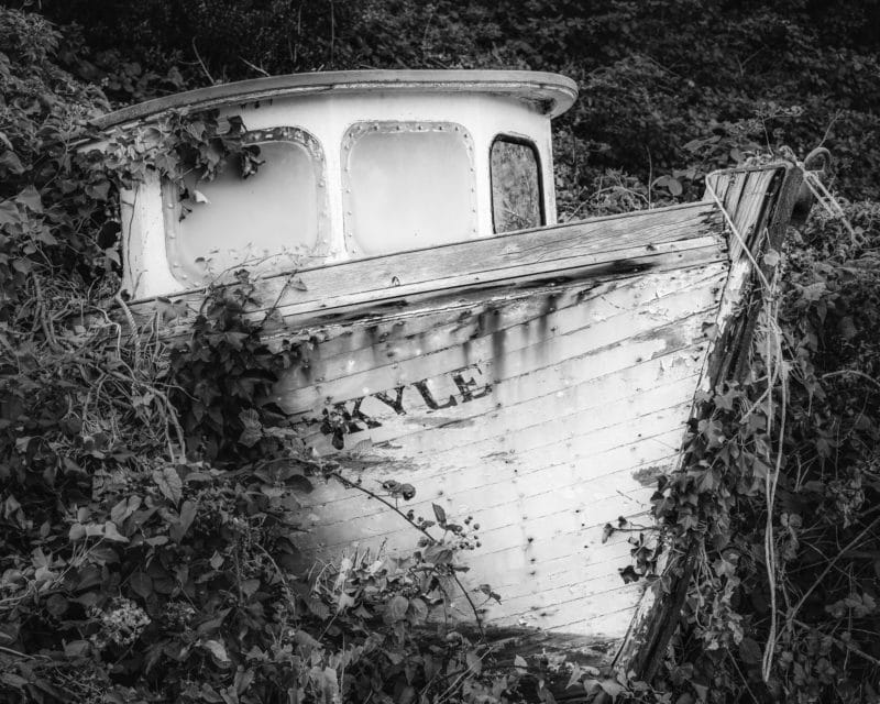 A black and white photograph of the boat "Kyle" grounded along the Willapa Bay coast at Bay Center, Washington.