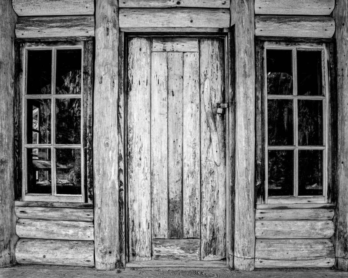 A black and white photograph of the front door and windows of the White River Patrol Cabin in Mt. Rainier National Park, Washington,
