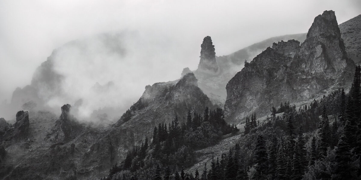 Behold the grandeur of nature in monochrome! This panoramic landscape photograph captures the mist-covered pinnacles below 3rd Burroughs Mountain, as seen from the Glacier Basin Trail in Mt. Rainier National Park, Washington.