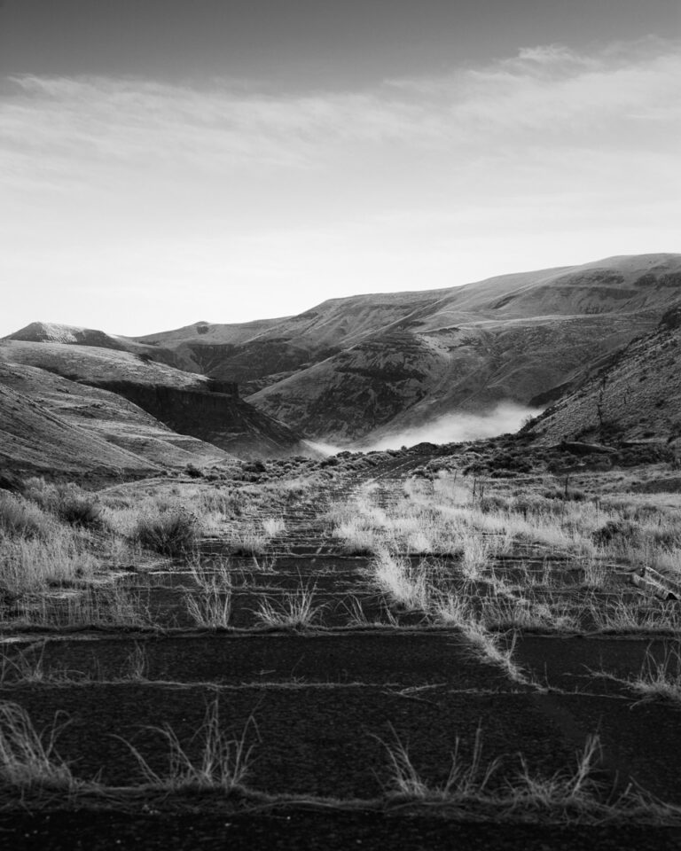 A black and white photograph of an abandoned section of old US 97 (now near SR 821) that used to route through the Yakima River Canyon in Yakima County near Selah, Washington before I-82 was constructed.