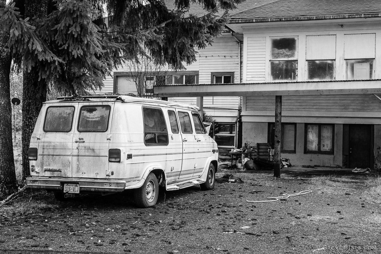 A black and white photograph of an abandoned Cheverolet van in Dryad, Washington.