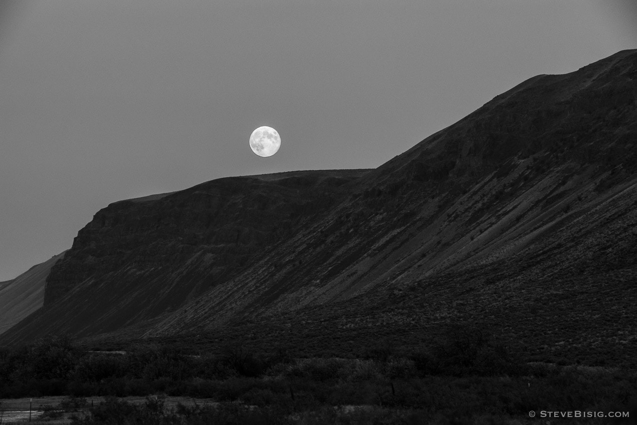 A black and white photograph of the August 31, 2012 Blue Moon rising over the Saddle Mountain Range at Lower Crab Creek near Beverly, Washington.
