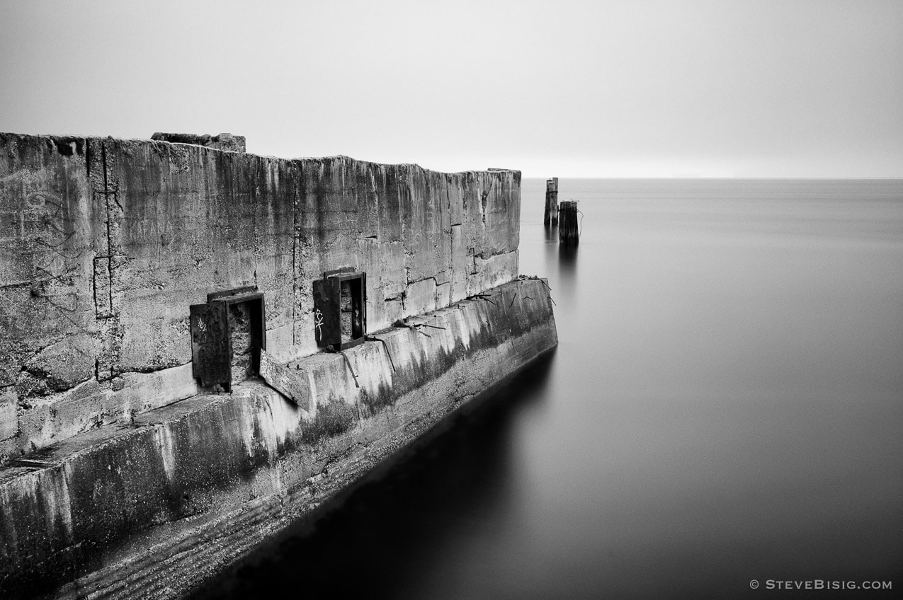 A black and white photograph of old concrete ruins from the Dickman Mill along the Puget Sound in Tacoma, Washington.