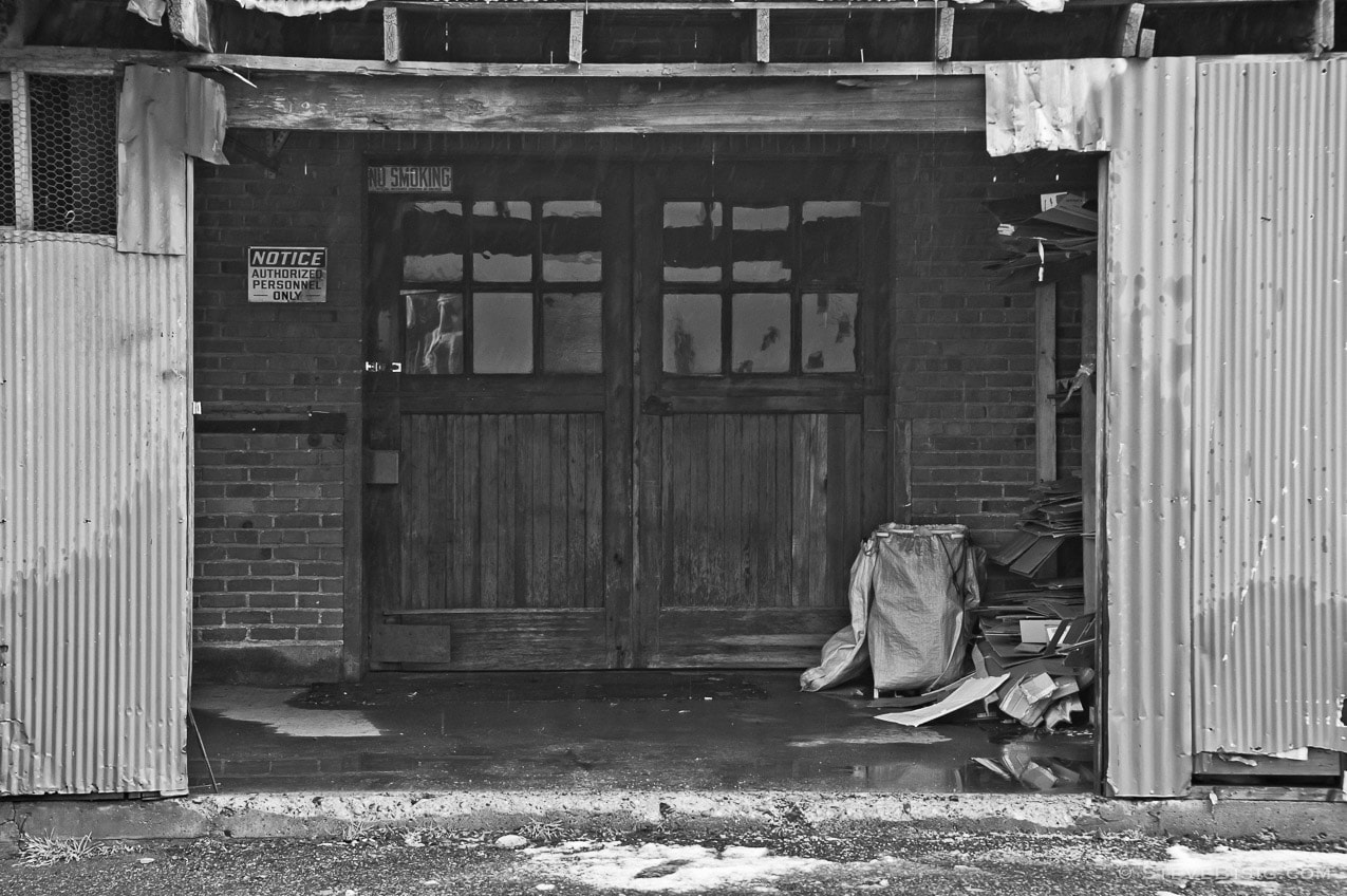 A black and white photograph of double doors under a lean-to on a historic building in Ellensburg, Washington