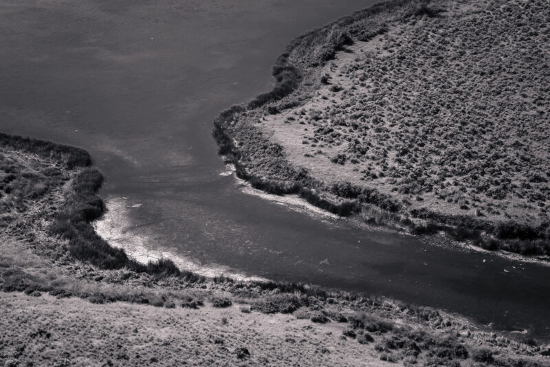 A black and white photograph of the shoreline around Dry Falls Lake in the Upper Grand Coulee, Washington.