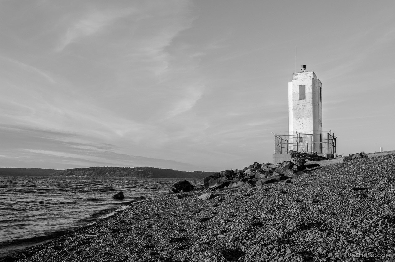 A black and white photograph of the Puget Sound and lighthouse at Browns Point, Washington.