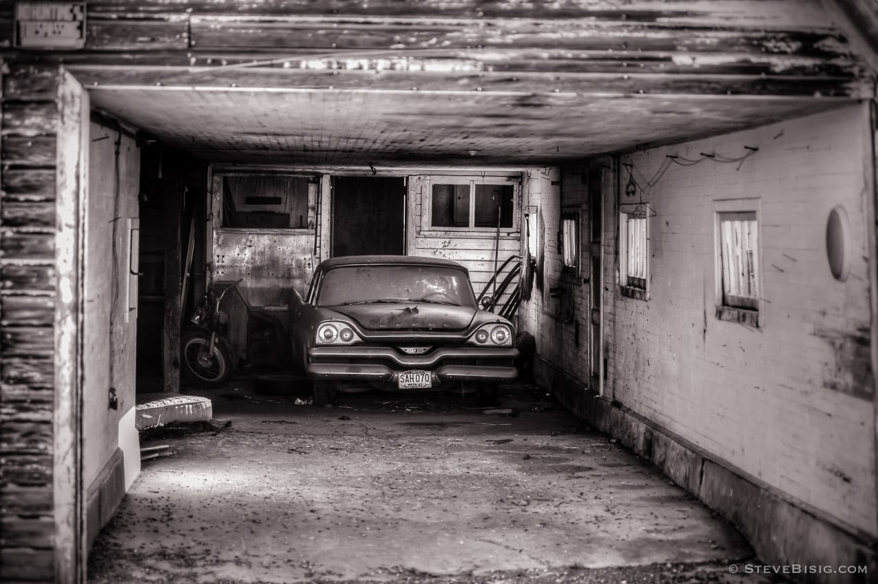 A black and white photograph of an old Dodge Coronet sitting in a garage near Ellensburg, Washington.