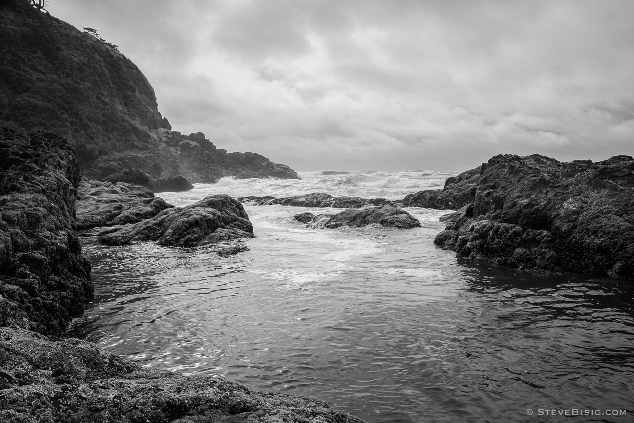 A black and white photograph of the rocky coastline of the Pacific Ocean near Seaview, Washington.